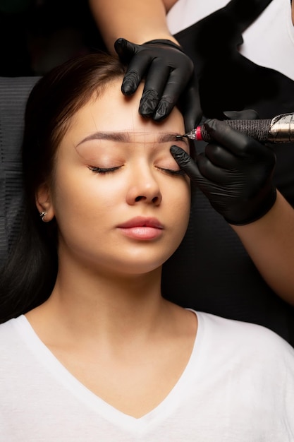 Maestro de belleza aplicando maquillaje de cejas en polvo permanente