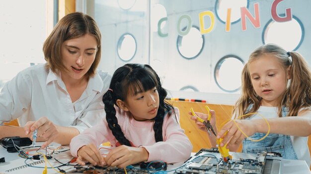 Un maestro caucásico enseñando a los estudiantes sobre la erudición de las herramientas eléctricas digitales