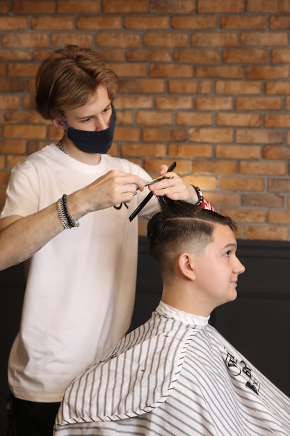 Maestro cortando el cabello de un hombre en una barbería