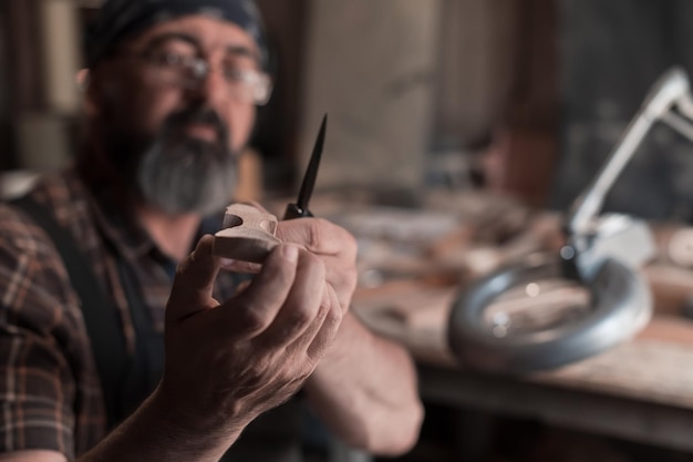 Maestro de cucharas en su taller con productos y herramientas de madera. foto de alta calidad