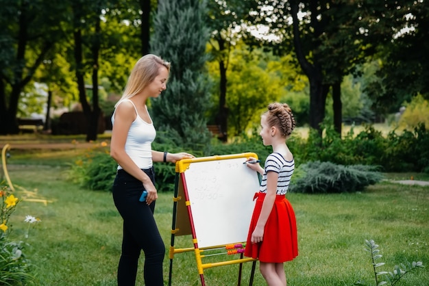 El maestro enseña a una clase de niños en un parque al aire libre