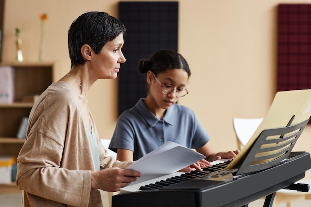 Maestro enseñando notas estudiante en clase de música