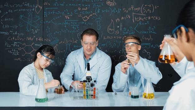 El maestro explica la teoría química mientras el estudiante mezcla la solución Edificación