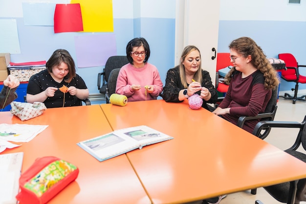 Foto un maestro guía a los estudiantes con discapacidades mentales, incluido el síndrome de down, en la costura