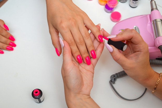 el maestro hace una manicura al cliente en un primer plano de manos de salón