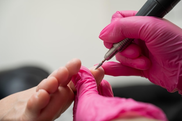 Foto el maestro hace pedicuras de hardware al cliente tratamiento de cutículas descalzo