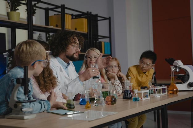 Un maestro haciendo experimentos científicos con sus estudiantes Foto de archivo