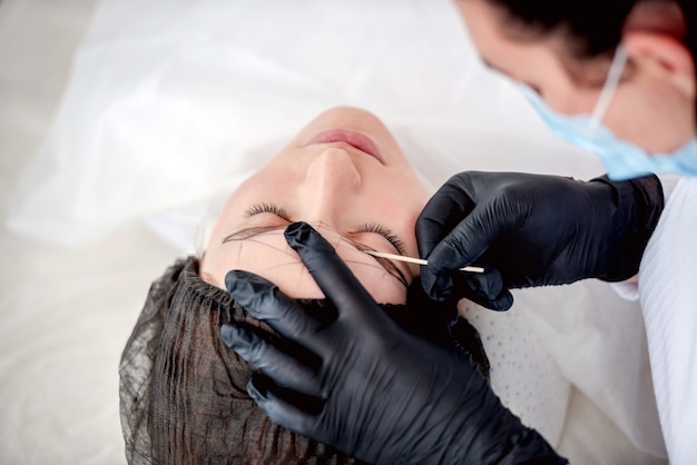 Maestro haciendo maquillaje permanente de cejas