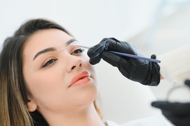 Maestro haciendo maquillaje permanente de cejas