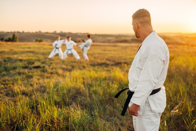 Maestro de Karate mira el entrenamiento de su clase