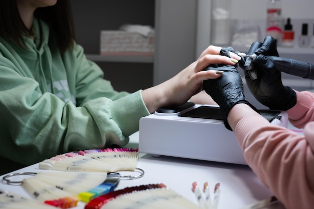 Maestro de manicura trabajando con una clienta en un salón de belleza