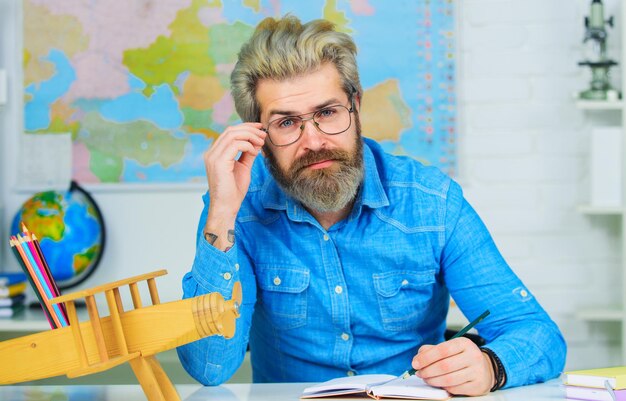 El maestro masculino prepara lecciones en el concepto de escuela de educación de aprendizaje en el aula de regreso a la escuela