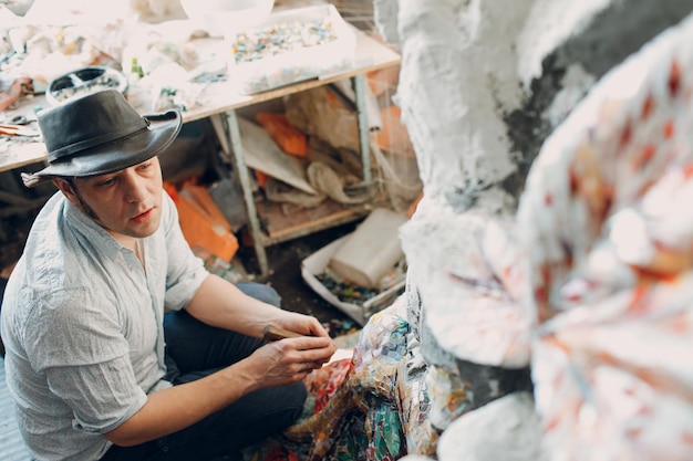 Maestro de mosaicos de hombre haciendo panel de mosaico de vidrio esmaltado Mosaicista masculino en el trabajo