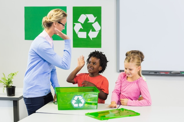 Maestro y niños dando chocar los cinco a los niños