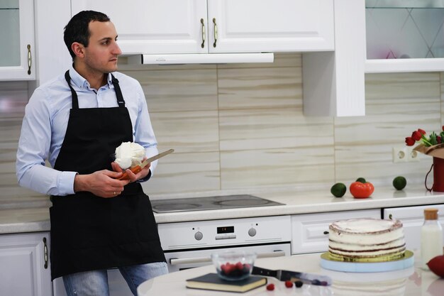 Maestro pastelero frente a un escritorio. Cocinar postres en casa. El hombre armenio se dedica a la repostería.