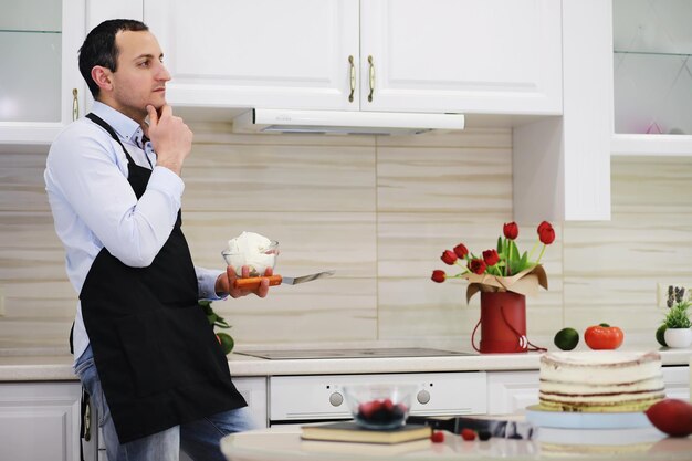 Maestro pastelero frente a un escritorio. Cocinar postres en casa. El hombre armenio se dedica a la repostería.