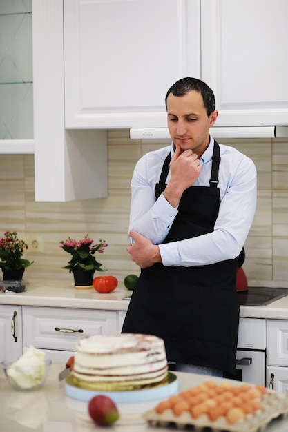 Maestro pastelero frente a un escritorio. Cocinar postres en casa. El hombre armenio se dedica a la repostería.