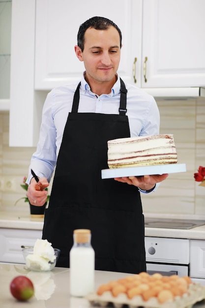 Maestro pastelero frente a un escritorio. Cocinar postres en casa. El hombre armenio se dedica a la repostería.