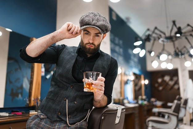 Maestro de peluquero con vaso de whisky