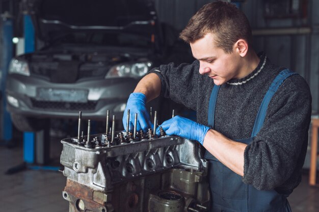 El maestro recoge un motor reconstruido para el automóvil.