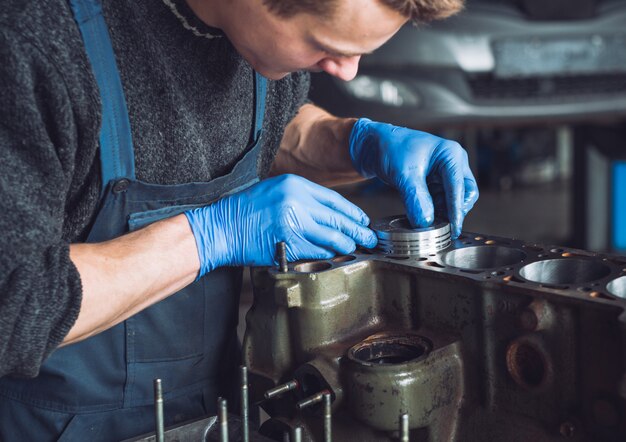 El maestro recoge un motor reconstruido para el automóvil.