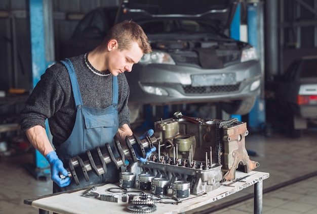 El maestro recoge un motor reconstruido para el automóvil.