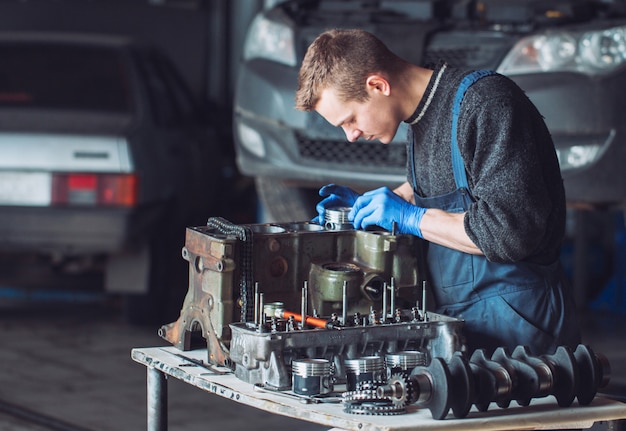 El maestro recoge un motor reconstruido para el automóvil.