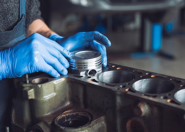 El maestro recoge un motor reconstruido para el automóvil.