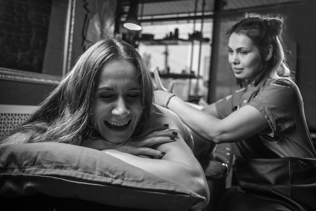 Maestro tatuador en el trabajo en el estudio de tatuajesArtista del tatuaje haciendo arte del tatuaje en el salón