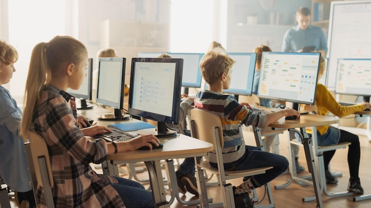 Foto un maestro trabaja en una computadora en un salón de clases.