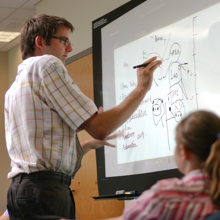 Foto un maestro usando una tabla inteligente para explicar un problema matemático complejo