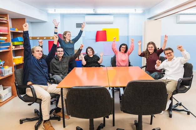 Maestros y estudiantes con discapacidad mental, incluidos los con síndrome de Down, celebrando con alegría