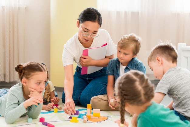 Foto maestros y niños que tienen una clase en el interior.