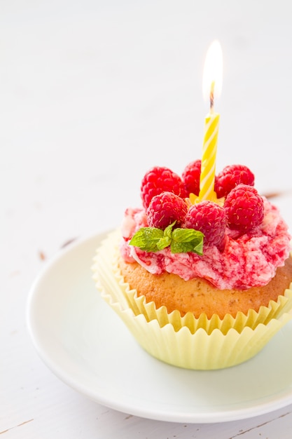 Foto magdalena de cumpleaños con frambuesa y caramelo.