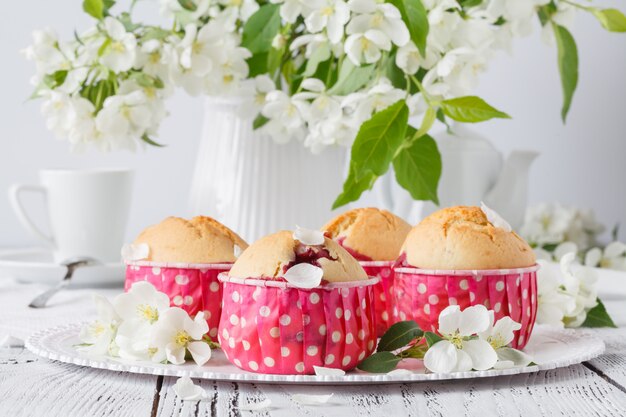 Magdalena o muffin con flor fresca en soporte de magdalenas de papel