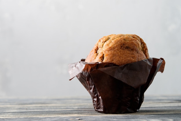 Magdalena ordinaria o muffin sobre un fondo de madera gris.