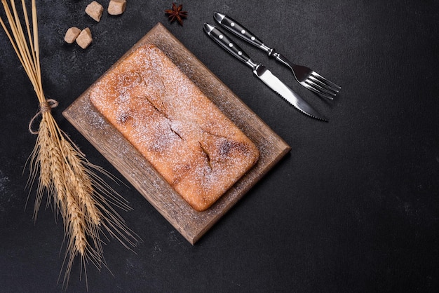 Magdalena rectangular horneada con pasas y chocolate sobre un fondo de hormigón oscuro Deliciosos pasteles caseros