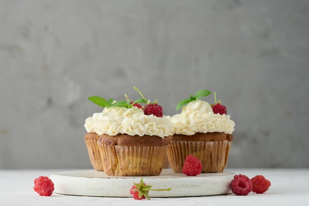 Magdalenas al horno con crema de mantequilla blanca sobre la mesa delicioso postre