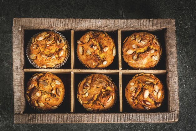 magdalenas de calabaza con especias tradicionales de otoño en mesa de corte de madera