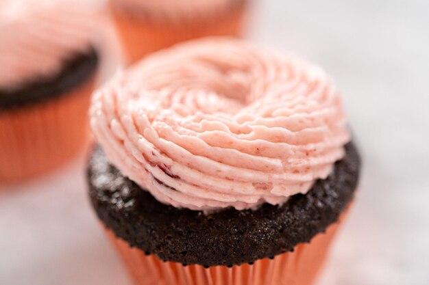 Magdalenas de chocolate cubiertas con glaseado de crema de mantequilla de fresa.