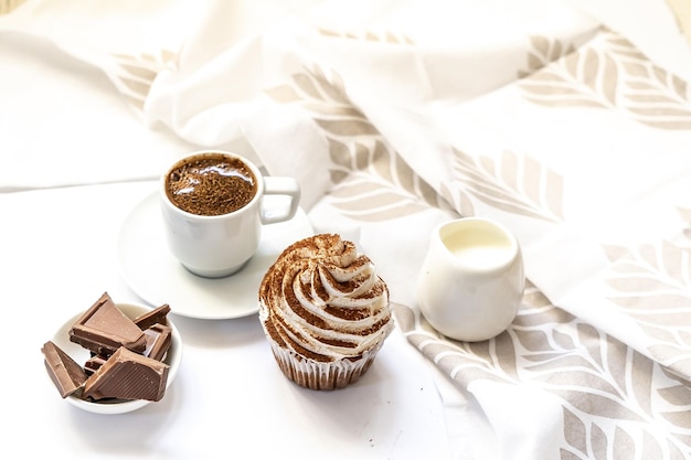 Magdalenas de chocolate negro y cacao con una taza de café negro caliente