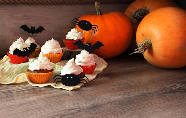 Magdalenas de especias de calabaza y calabazas grandes en escena de otoño.