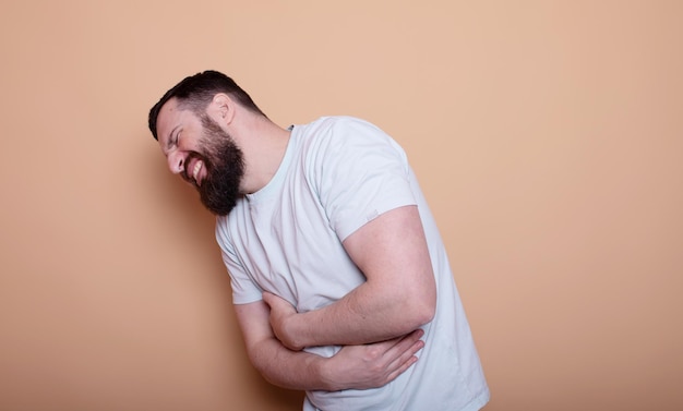 Magenschmerzen und andere Magenkrankheiten Konzept Bärtiger Mann berührt seinen Magen