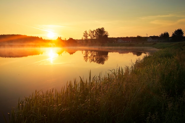 Mágica puesta de sol sobre el lago en el pueblo Composición de la naturaleza