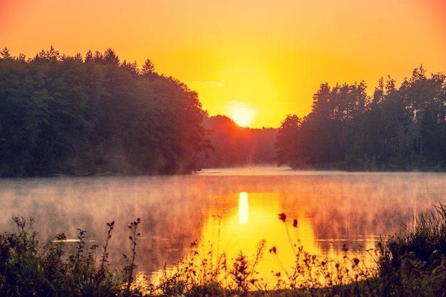 Mágico amanecer sobre el lago con un hermoso reflejo en el agua. Lago sereno temprano en la mañana. Paisaje de la naturaleza