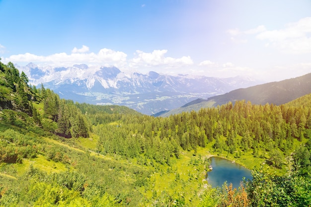 Mágico paisaje idílico con lago en las montañas de los Alpes de Europa. ruta turística en colinas verdes en los Alpes. Hermosa roca y admire la increíble vista a los picos de las montañas. Fantástico día soleado en el lago de montaña.