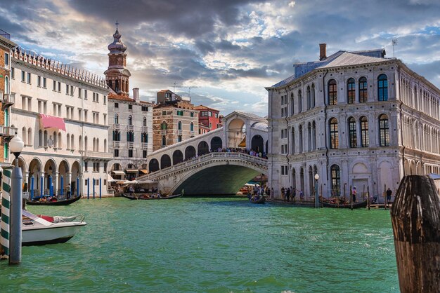Magische Aussicht auf die traditionelle Gondel in der Nähe des weltberühmten Canal Grande und der Rialtobrücke bei Sonnenuntergang in Venedig, Italien. Retro-Vintage-Instagram-Filter und Flare-Effekt hinzugefügt.