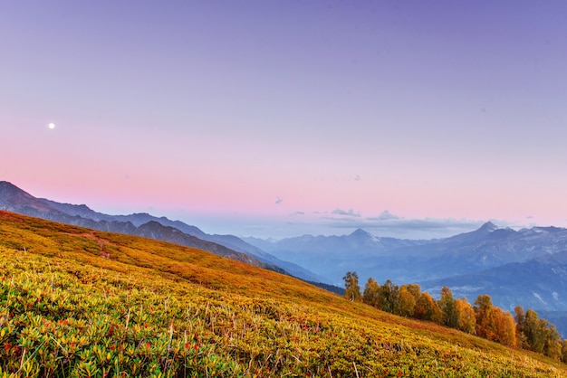 Magische Herbstlandschaft und schneebedeckte Berggipfel. Ansicht von t