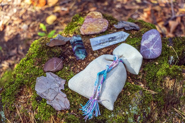 Magischer Fluorit, Quarzkristall, Kerze und Beutel mit Trank. Felsen für mystisches Ritual, Hexerei