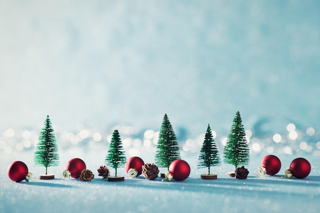 Foto magisches miniatur-winter-wunderland hintergrund immergrüne bäume kiefernkegel und weihnachtskugeln